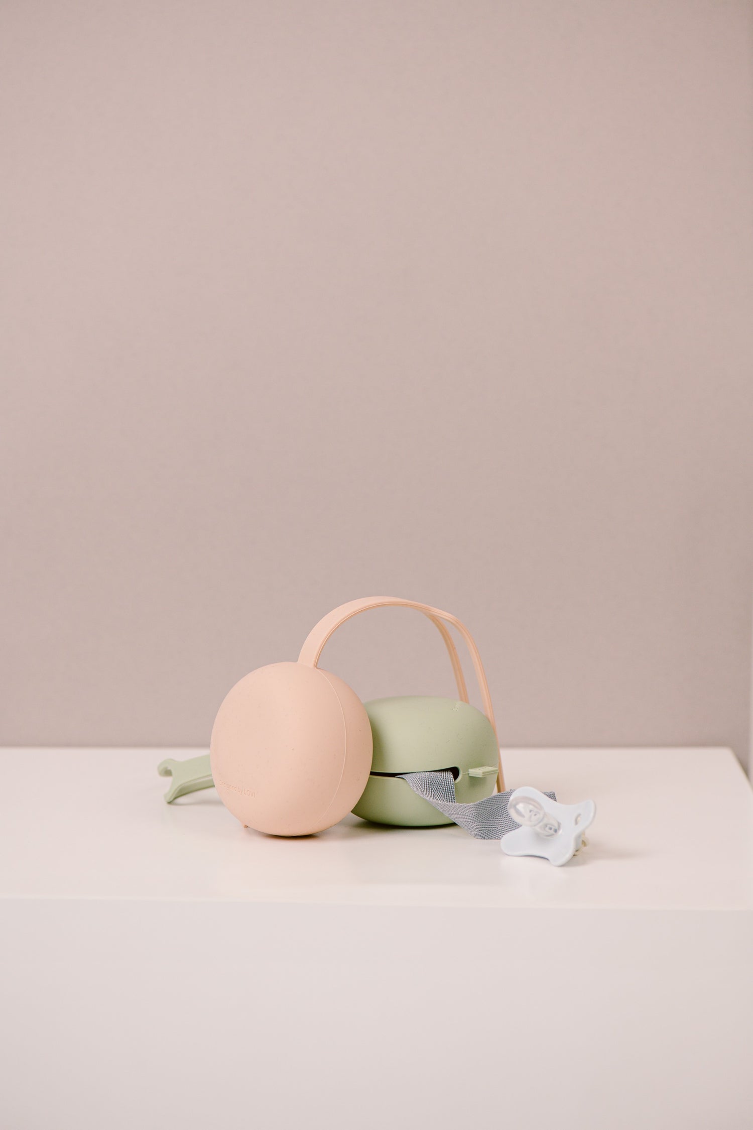 Difrax Lovi - Silicone Soother Holder - Pistachio & Nude on Table