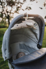 Liva Heartbeat Comforter OTG - Tied to Pram with Baby Closeup - Oat