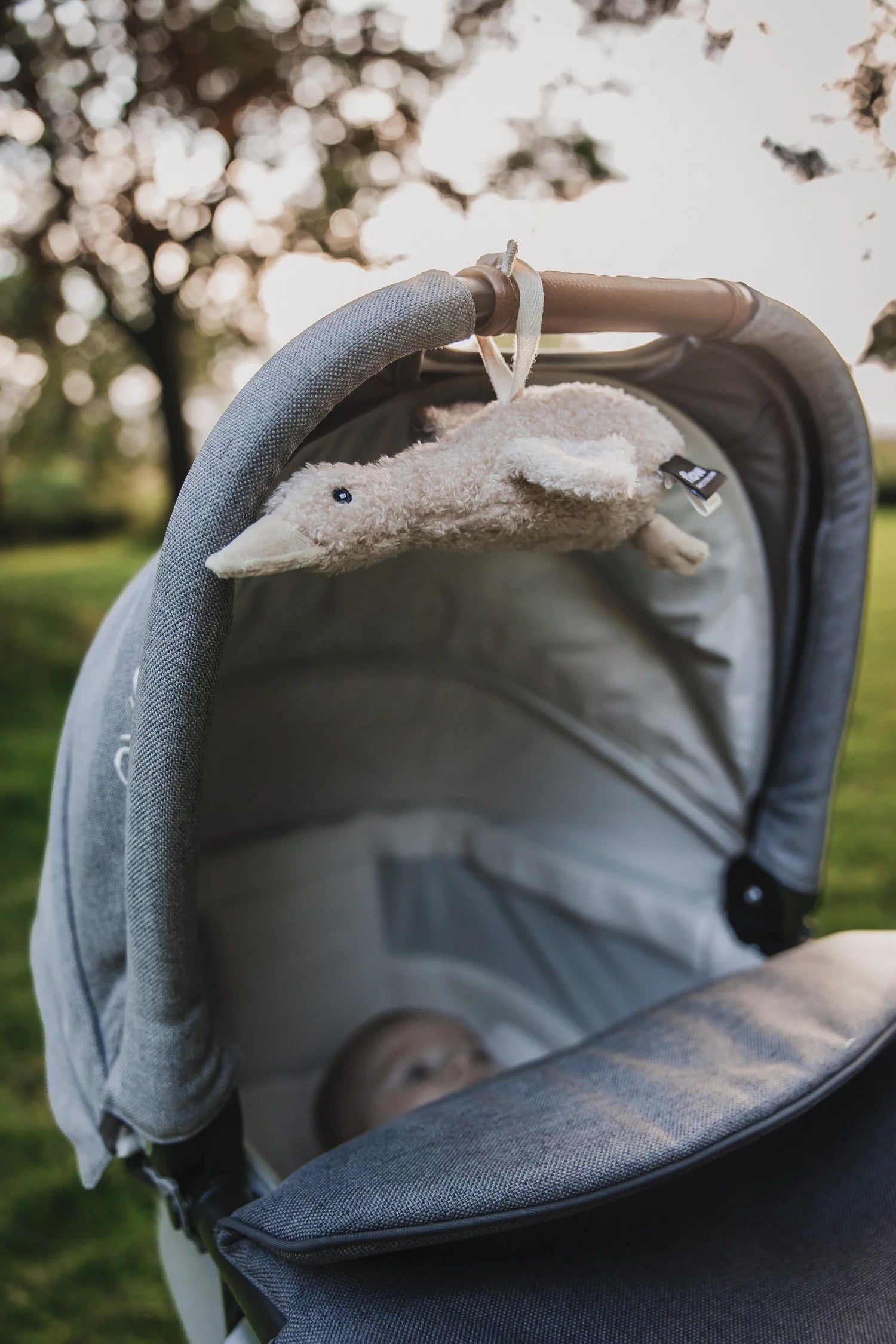 Liva Heartbeat Comforter OTG - Tied to Pram with Baby Closeup - Oat